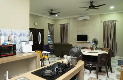 a living room with a kitchen and a living room with a stove at KT’s Lake House in Ipoh