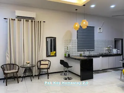 a kitchen with chairs and a table in a room at ISLAMIC Pak Kop Homestay with private pool 2 in Parit Buntar