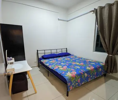 a small bedroom with a bed and a table at IZZ Homestay MUSLiiM in Ipoh