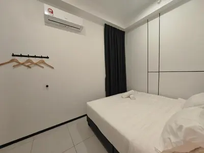 a white bedroom with a bed and a air conditioner at Modern Elegance - Urban Suites by Ocean Luxe in Jelutong