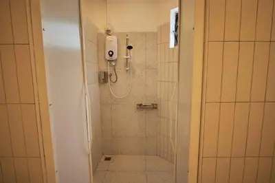 a bathroom with a shower with a tiled floor at Some Place Else in George Town