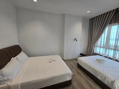 a bedroom with two beds and a large window at The Octagon Premium Suite - Ipoh in Ipoh
