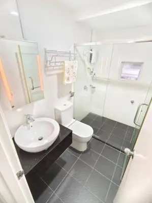 a white bathroom with a toilet and a sink at Maritime Suite Penang - City & Sea view in George Town