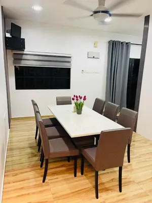 a dining room with a white table and chairs at The SilverCity Homestay Ipoh in Ipoh