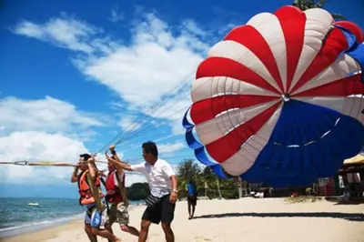 a group of people on a beach with a large parachute at Bintara Guesthouse Sri Sayang Batu Ferringhi in Batu Ferringhi