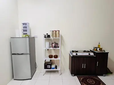 a kitchen with a stainless steel refrigerator and a shelf at D'Iman UTP Seri Iskandar Homestay in Kampung Bota Kiri