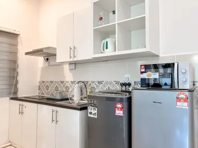 a kitchen with white cabinets and a refrigerator at ANDERSON 2 Room Suite for 6-7 pax in Ipoh