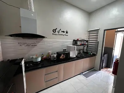 a kitchen with a counter with pots and pans at Matsurika Guest House - Kulim in Kulim