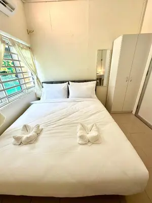 a white bed with two bows on top of it at K Inn 55 in George Town