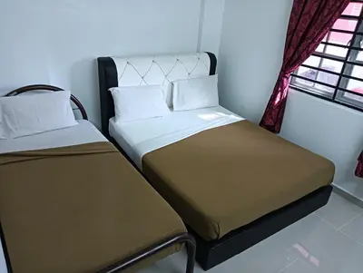 two beds in a small room with a window at Yaakub homestay pangsapuri sutera jaya in Perai