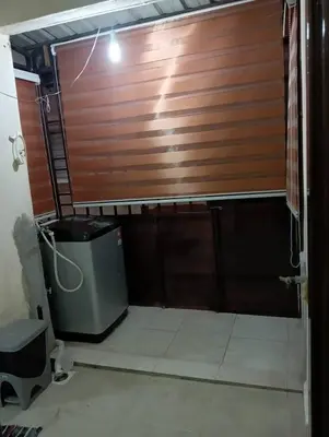 a wooden garage door in a room with a trash can at Yaakub homestay pangsapuri sutera jaya in Perai