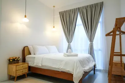 a bedroom with a bed with white sheets and a window at Bunny's Warm Penthouse by Comfy Sofy in Brinchang