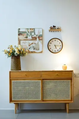 a cabinet with a clock and a vase with flowers at Bunny's Warm Penthouse by Comfy Sofy in Brinchang
