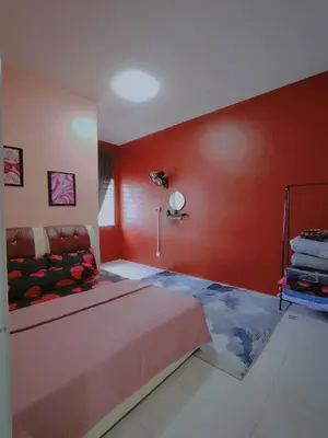 a bedroom with a bed and a red wall at DLAZ HOMESTAY in Tanah Rata