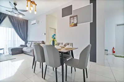 a dining room and living room with a table and chairs at The Horizon Ipoh Belle Vue by Grab A Stay in Ipoh