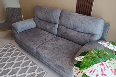 a blue couch in a living room with a plant at The Horizon Ipoh Dual L13A by Grab A Stay in Ipoh