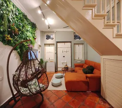a living room with an orange couch and a staircase at New! 9 pax Georgetown Heritage Pre-war House 3BR in George Town