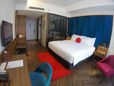 a hotel room with a bed and a desk and chairs at WEIL Hotel Ipoh in Ipoh