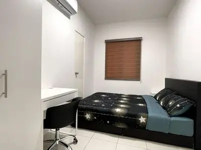 a bedroom with a bed and a desk and a chair at Premier Family Suite & City View Seven Houz Ipoh in Ipoh