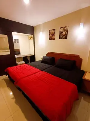 a bedroom with a large red bed in a room at Marina HOMESTAY JETI LUMUT MANJUNG in Lumut