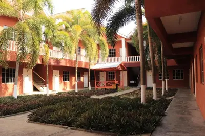 a building with palm trees in front of it at Hornbillbay Beach Resort in Kampung Teluk Nipah
