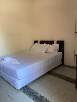 a bed with white sheets and pillows in a room at Hornbillbay Beach Resort in Kampung Teluk Nipah