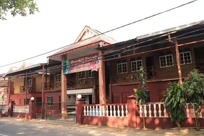 a red building with a fence in front of it at Hornbillbay Beach Resort in Kampung Teluk Nipah