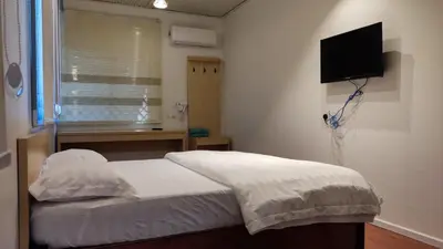 a bedroom with a bed and a television on the wall at Scotland 18 Lodge in George Town