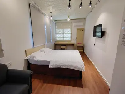 a small bedroom with a bed and a desk at Scotland 18 Lodge in George Town