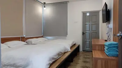 a bedroom with two beds and a tv and a door at Scotland 18 Lodge in George Town