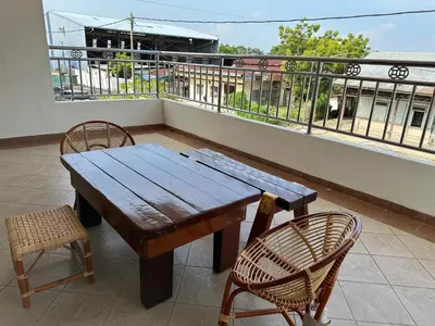 a wooden table and two chairs on a balcony at UncleLiew Cozy Home \u8001\u5218\u6c11\u5bbf in Sekincan
