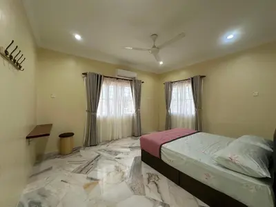 a bedroom with a bed and two windows at UncleLiew Cozy Home \u8001\u5218\u6c11\u5bbf in Sekincan