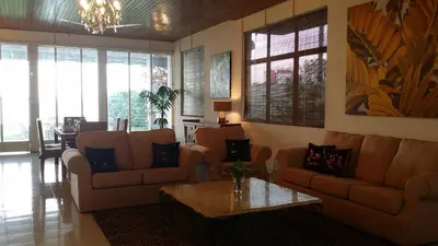a living room with couches and a table and a dining room at Beach Front Bungalow Tanjung Bungah in George Town
