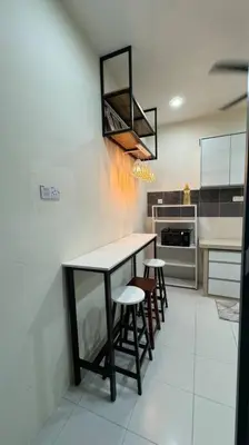 a kitchen with a table and stools in it at Homestay Bagan Serai in Bagan Serai