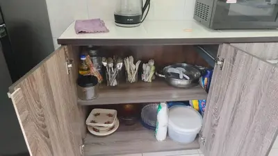 a cupboard with dishes and utensils in a kitchen at City View Apartment in Ipoh