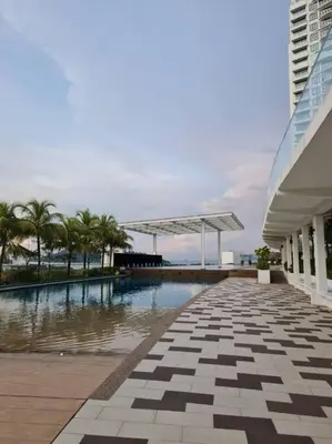 a swimming pool with palm trees and a building at Southbay Seaview Condo A10 10minQueensbay 10minSpice in Bayan Lepas