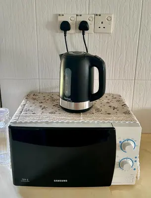 a black coffee pot sitting on top of a microwave at Pengo Homestay Georgetown in George Town