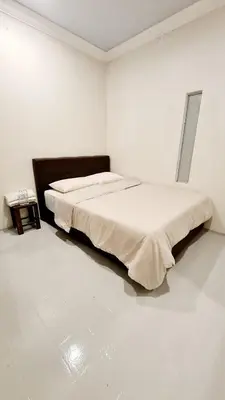 a white bedroom with a large bed in it at Pine Lodge BY EVR Previously YSS indrawasih in Perai