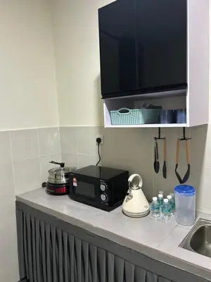 a kitchen counter with a microwave and a sink at SKV Homestay in Teluk Intan