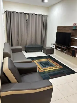 a living room with a couch and a flat screen tv at SKV Homestay in Teluk Intan