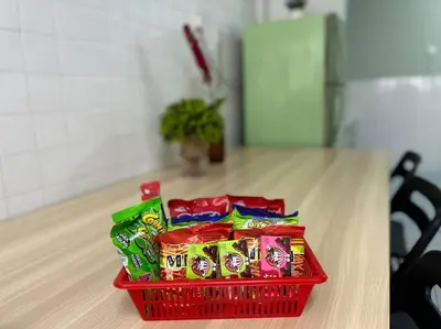 a red basket of candy on a table at Ipoh Comfortable Family Homestay 4R3B 12pax SY25 in Ipoh