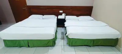 two beds in a room next to each other at Kampar Times Inn Hotel in Kampar