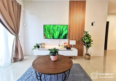 a living room with a table and a flat screen tv at FE Cozy Ipoh Homestay Manhattan Condominium Ipoh Waterpark 3BR 8 pax by FE Homestay \u6021\u4fdd\u6c11\u5bbf \u6c34\u4e0a\u4e50\u56ed in Ipoh