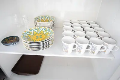 a white shelf with cups and plates on it at Tanjung Bungah 5BR Villa w pool 20pax in Tanjung Bungah