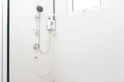 a shower in a bathroom next to a door at Tanjung Bungah 5BR Villa w pool 20pax in Tanjung Bungah