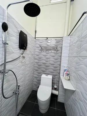 a small bathroom with a toilet and a shower at De Raisha Homestay in Butterworth