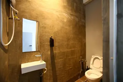 a bathroom with a toilet and a sink and a window at HangoutSpacez Queensbay at Bayan Lepas Penang in Bayan Lepas