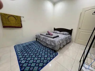 a small bedroom with a bed and a blue rug at ADZ Islam Homestay Simpang Pulai in Kampong Kepayang