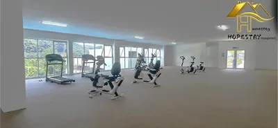 a gym with treadmills and ellipticals in a room with windows at Anderson Suite by Hopestay Property Management in Ipoh