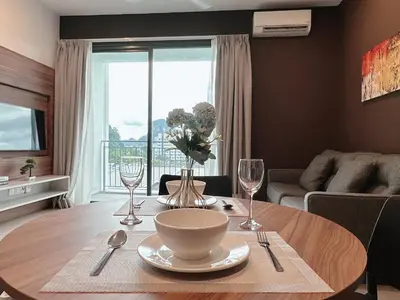 a living room with a table with a vase of flowers at Sunway Onsen Suite Cozy Homestay in Ipoh